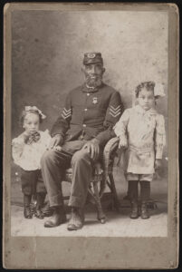 Unidentified African American Civil War veteran in Grand Army of the Republic uniform with two children