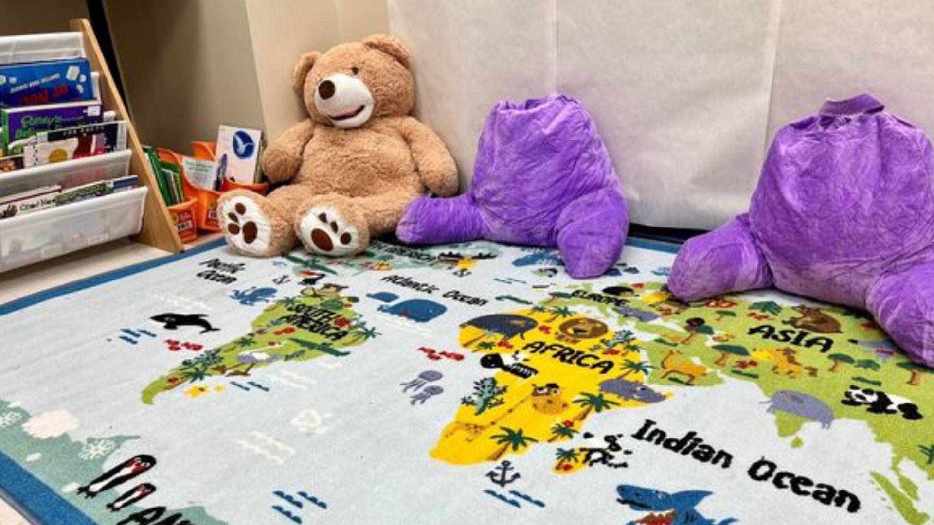 Classroom with stuffed animals and a rug.