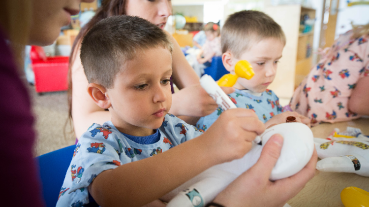 Missouri State University students studying child life work with children in a therapy setting.
