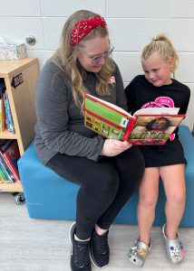 Lexi Messenger reads to a student.
