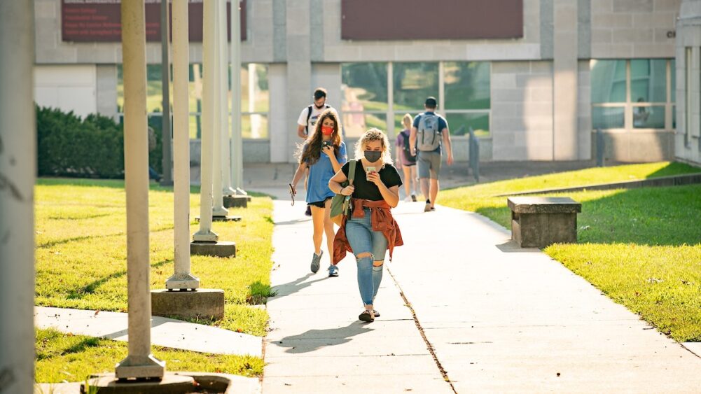 Students walk to their next class on a sunny day.
