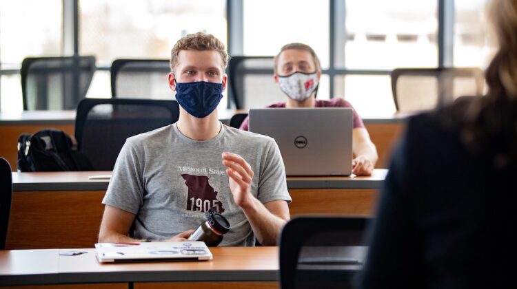Masked students participate in a class discussion.
