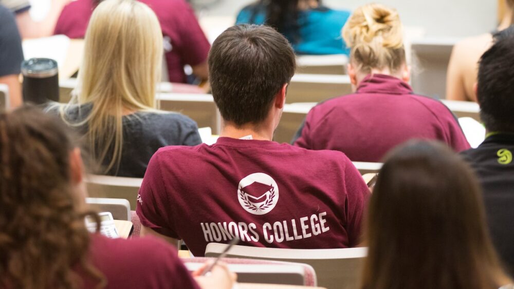 A student wearing a Missouri State Honors College T-shirt listens during their class.