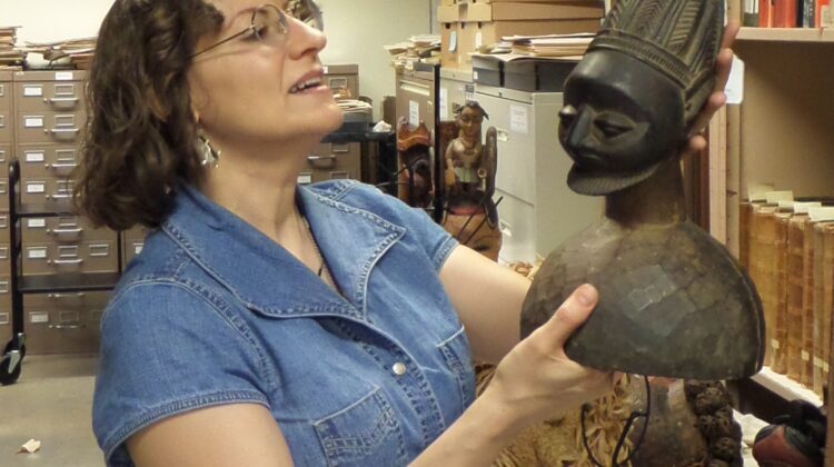 Dr. Billie Follensbee holds an African bust.