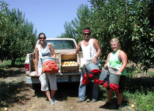 Noelle, Ruben and Kayla pause for a group shot with their Gala apple harvest.