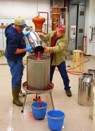 CJ and Karl pour raspberries that were soaked in neutral spirits overnight into the press