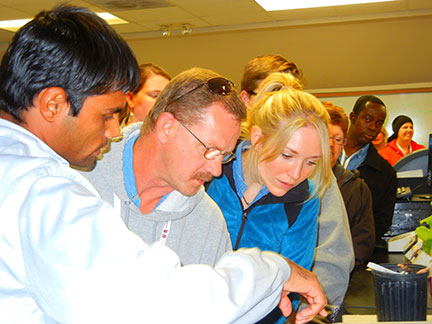 Surya Sapkota, left, points out differences in the berry rot assay.