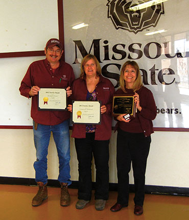 Randy, Susanne (middle) and Pam hold up their service award plaques they received from President Smart.