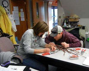Jeremy Emery shows Shelia Long how to slice through a grape bud in order to assess injury.