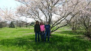 Shelia (left), Beth and Sarah take a moment to enjoy the flowering Cherry tree It seemed to escape much of the late frost injury that claimed other flowers.