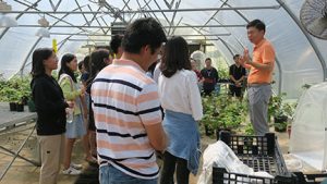 Dr. Wenping Qiu talks about his research programs during a tour of the greenhouses.
