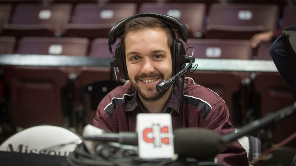 Matt Lerman wears a headset on press row before a Bears basketball game at JQH Arena.