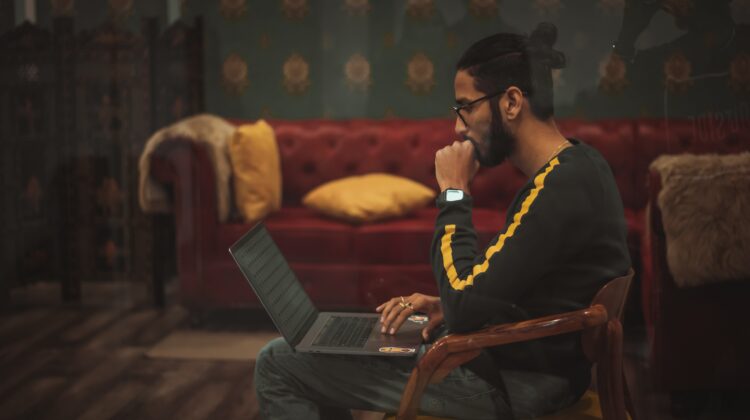 Man sitting at a computer, thinking.