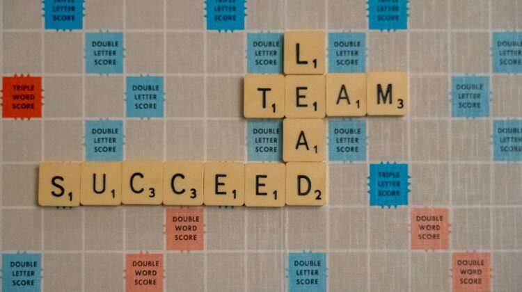Tile letters on Scrabble board Lead Team Succeed