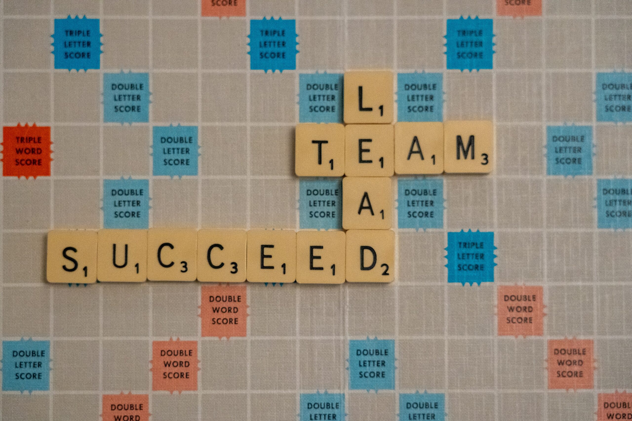 Tile letters on Scrabble board Lead Team Succeed