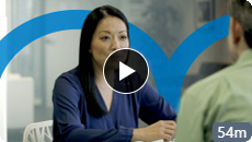 Image of a woman talking to another person. A Play video button is in the center.