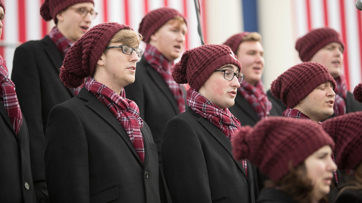 Chorale performs in hat and scarf