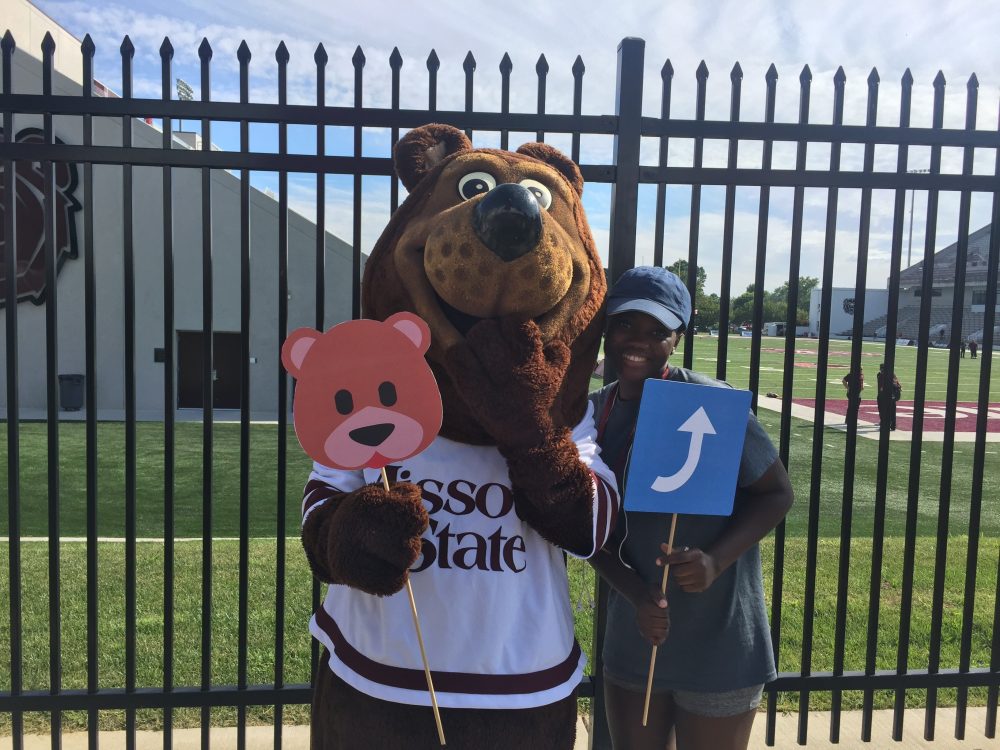 Boomer Bear mascot poses with an international student
