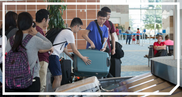 Photo of new international students receiving help with luggage upon arrival in Springfield, Missouri.