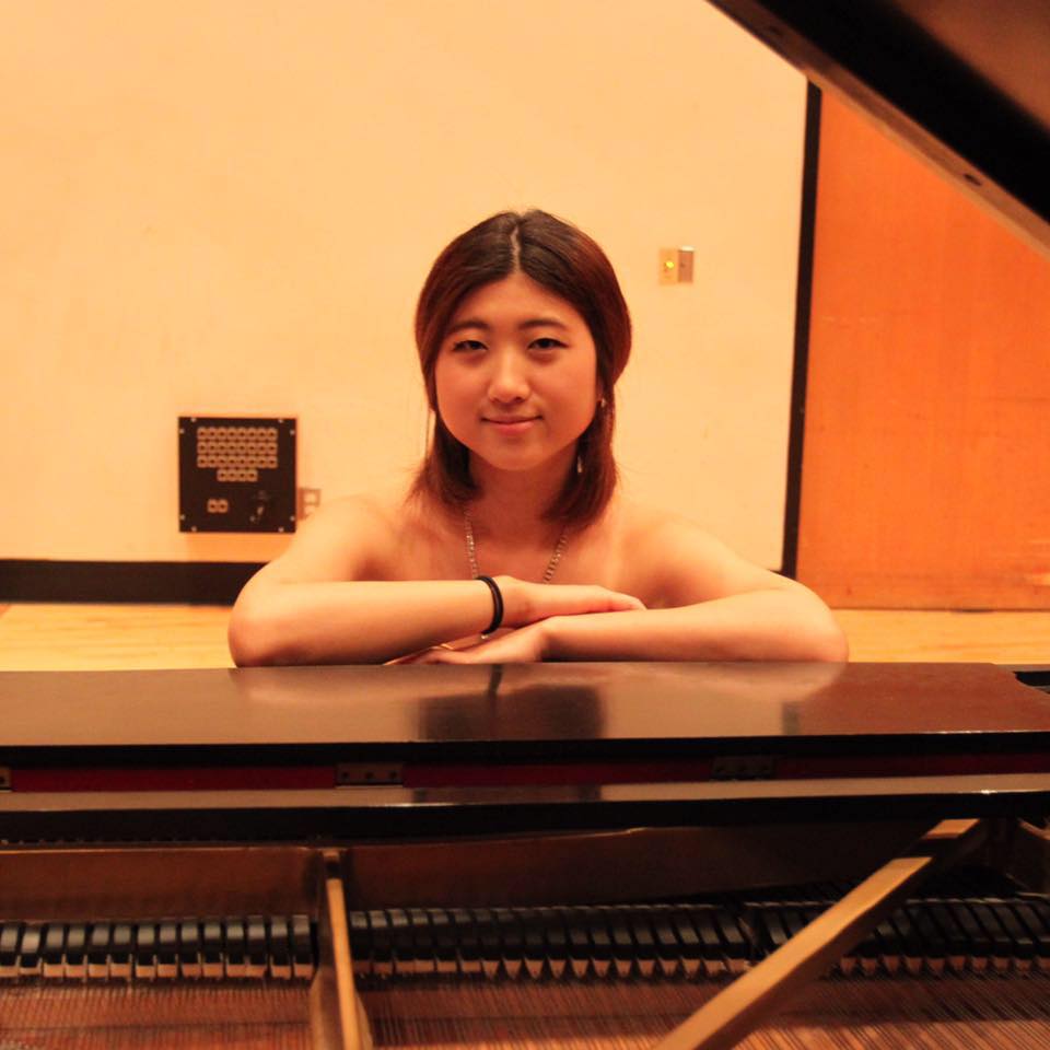 student in front of a piano