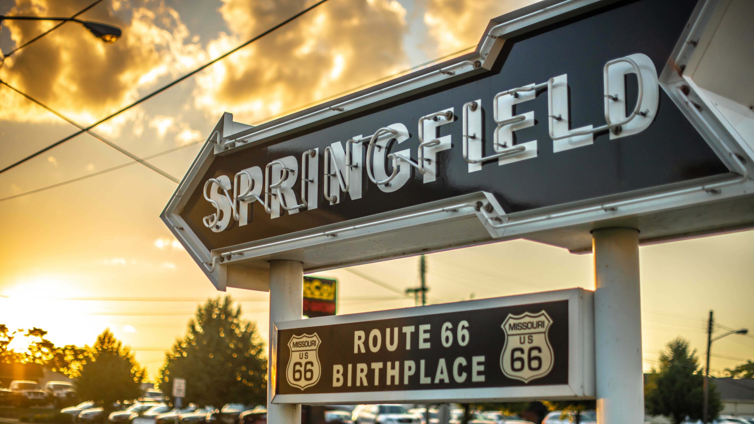 A picture of a sign that reads, "Springifeld: Birthplace of Route 66" at sunset