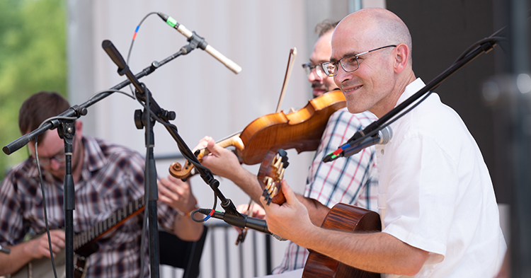 A musician plays the fiddle on the National Mall as part of the annual Smithsonian Folklife Festival
