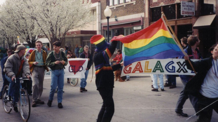 Participants wave a pride flag and GLO banner at a Springfield