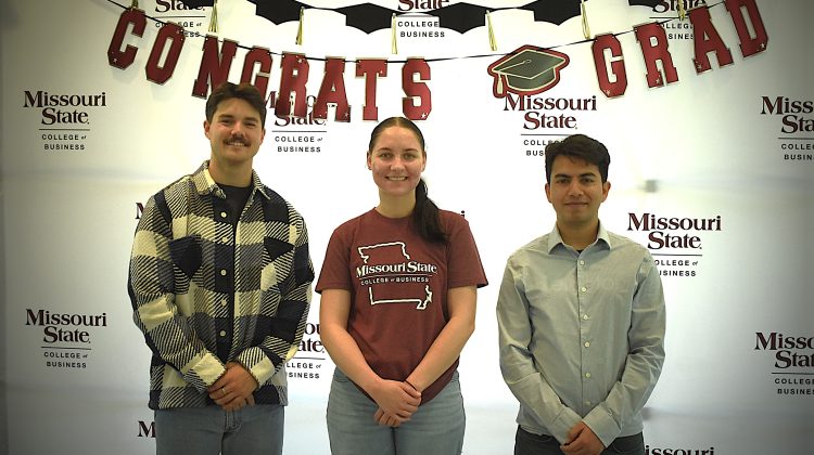 MSU Graduate Assistants Ethan D. Scott, Brenna Breitenstein, and Avas Basnet posing together after graduation at Missouri State University.