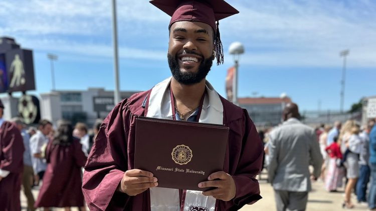Rodell Andrews, a Bachelor of General Studies student, holds his diploma after his commencement ceremony.