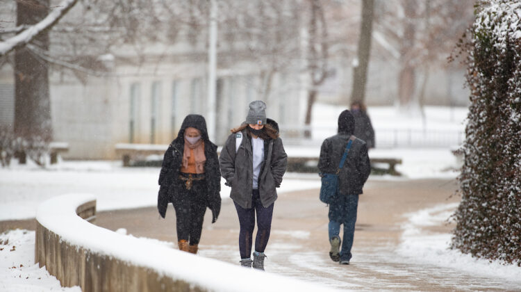 students walk in the snow on campus