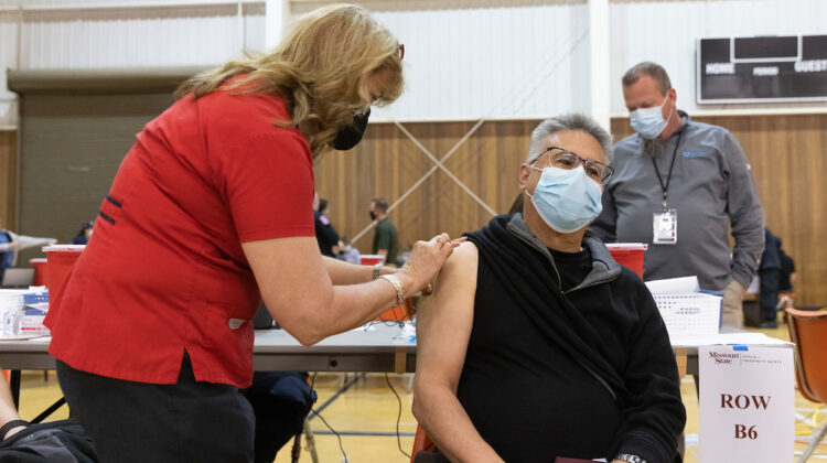 Man receives vaccine from nurse