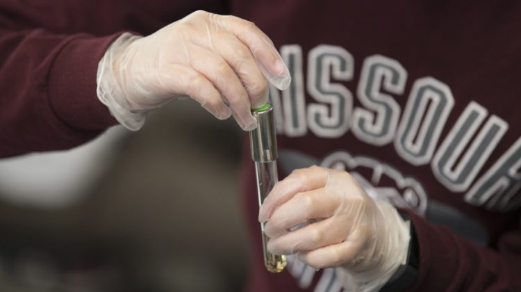 A Missouri State student holds a test tube.