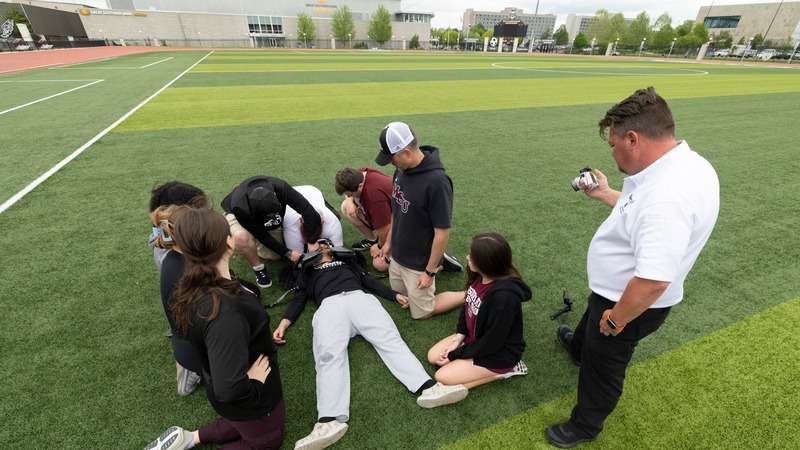 Athletic training students practice emergency injury response during a hands-on simulation exercise.