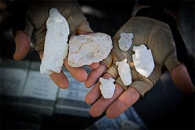 Man holding a collection of stone artifacts
