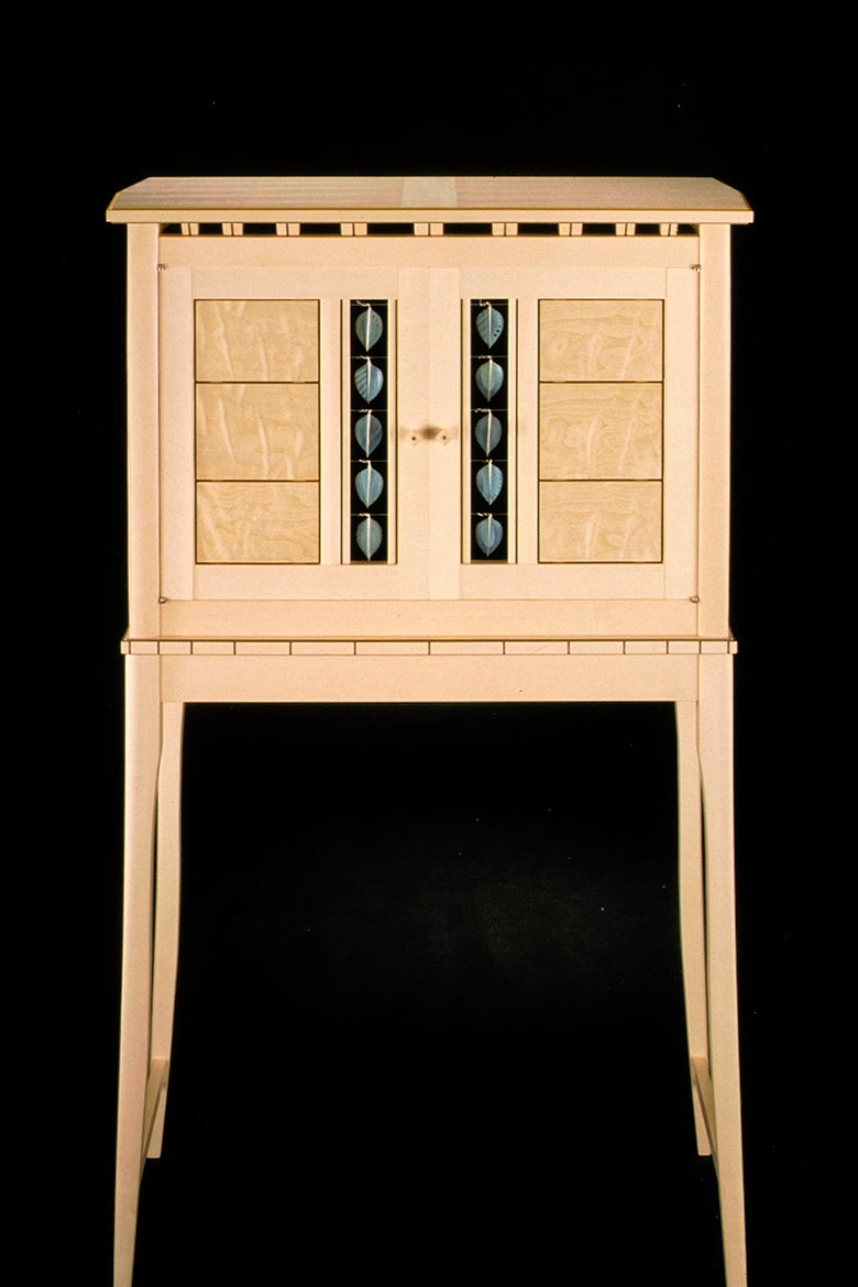 Front-view of wood furniture piece with enameled metal accents