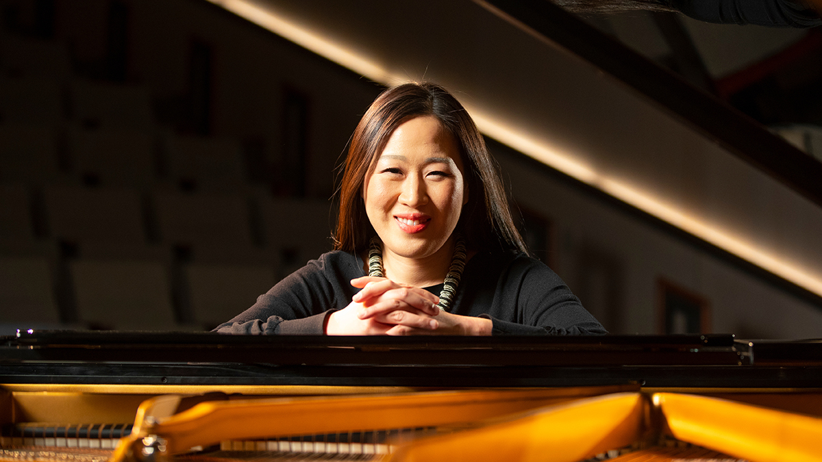 Minju Choi Witte peers through the open top of a grand piano