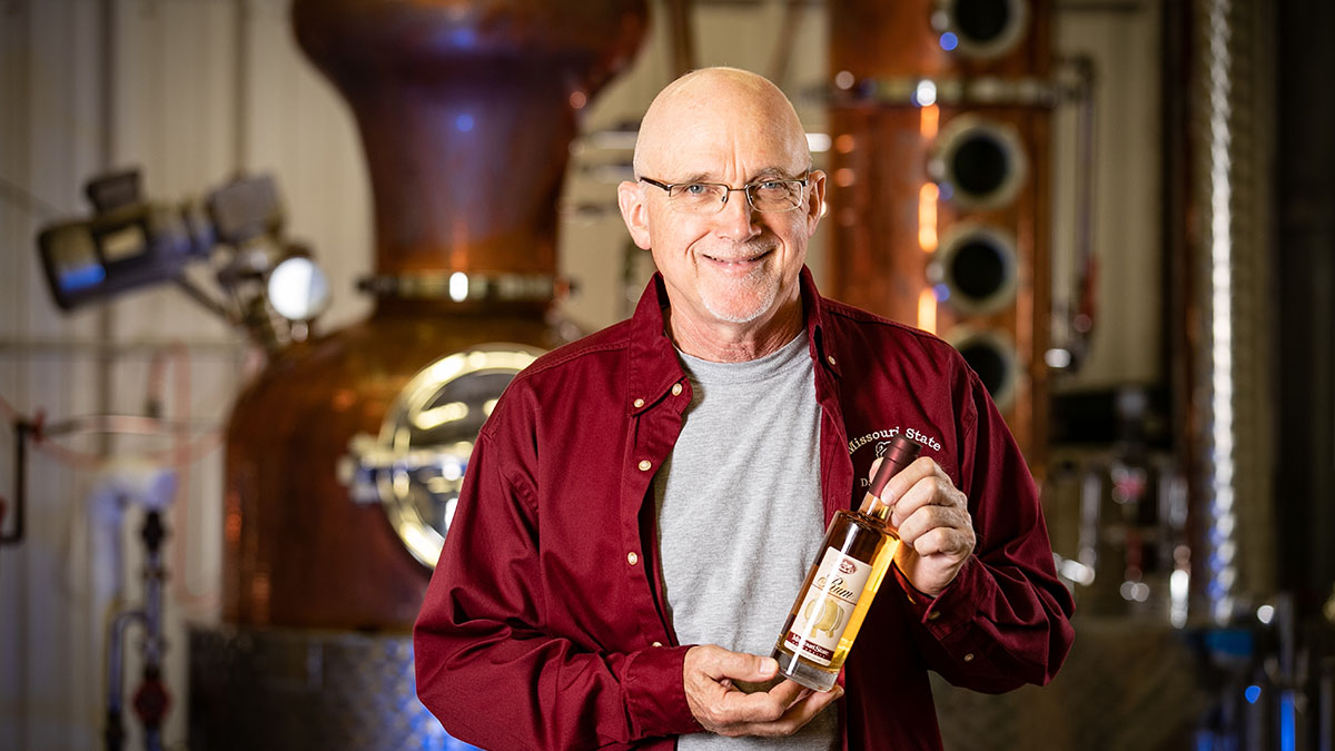 Karl Wilker with award-winning rum in distillery