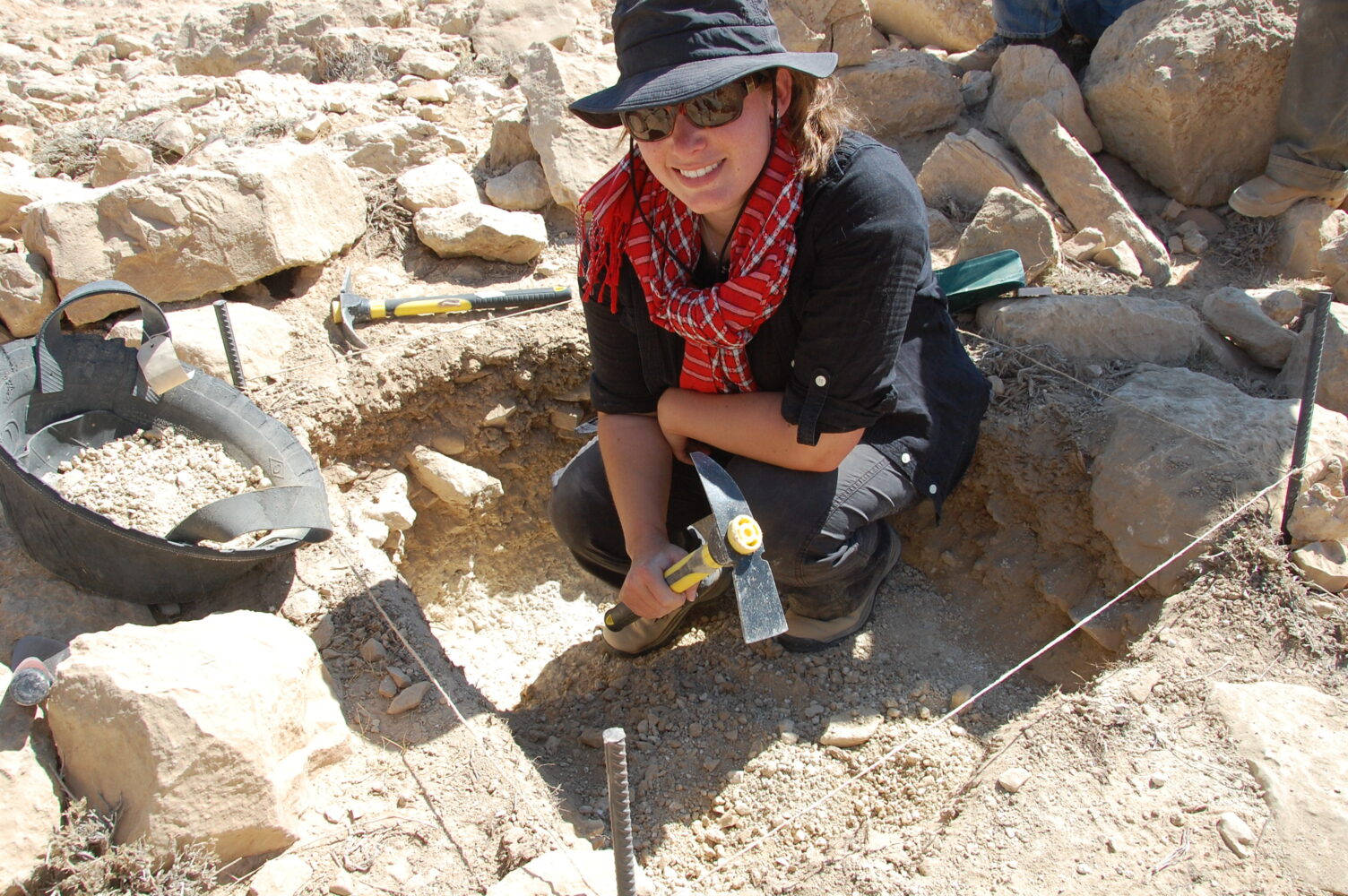 Julia squats near dig site in Petra, Jordan.