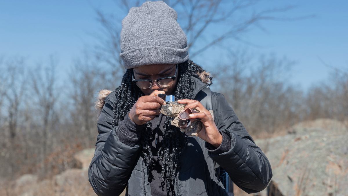Oluchi Nweke examines rock with a hand lens.