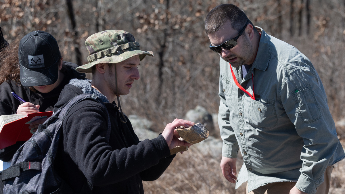 Student consults with Dr. Gary Michelfelder in mountainous area.