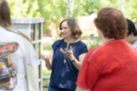 Dr. Marnie Watson speaks with a group of individuals at Eden Village.