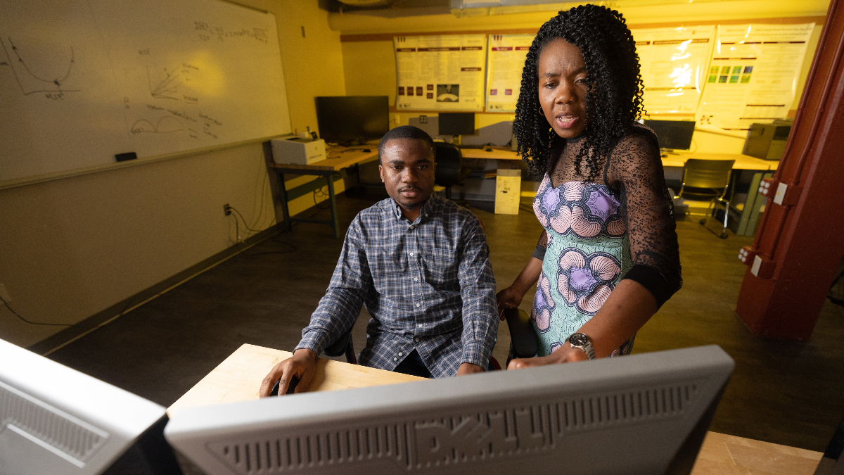 Tayo Obafemi-Ajayi gestures to computer screen that her student is working on.
