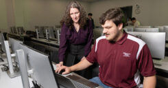 Dr. Adams assists an accountancy student with his classwork on the computer.