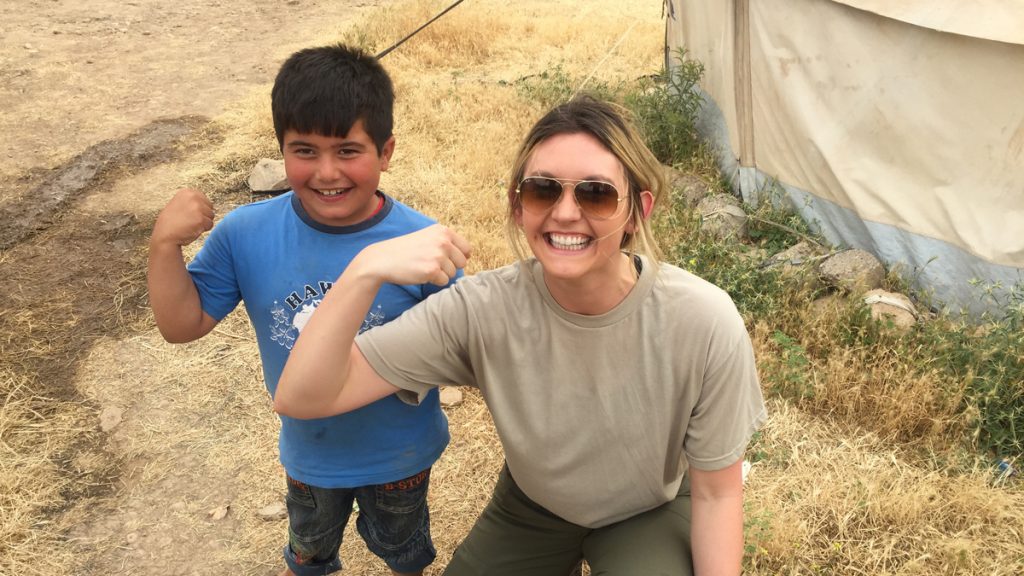 Madeline Hayes with a kid in Mosul