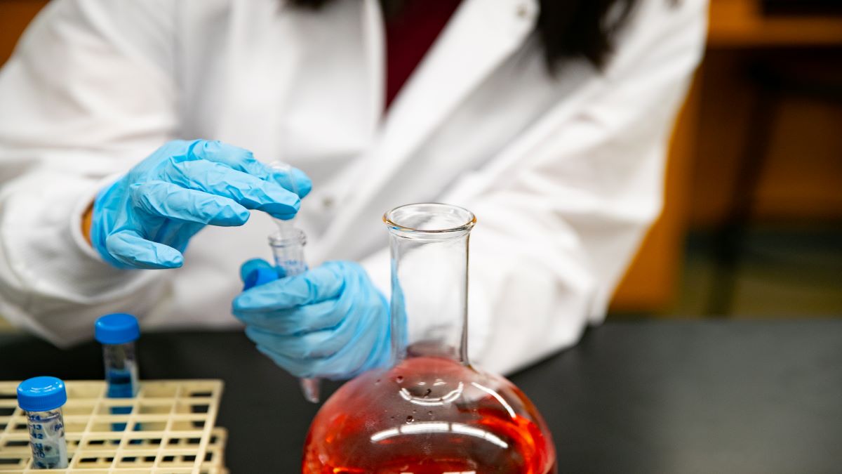 A student filling a beaker with chemicals.