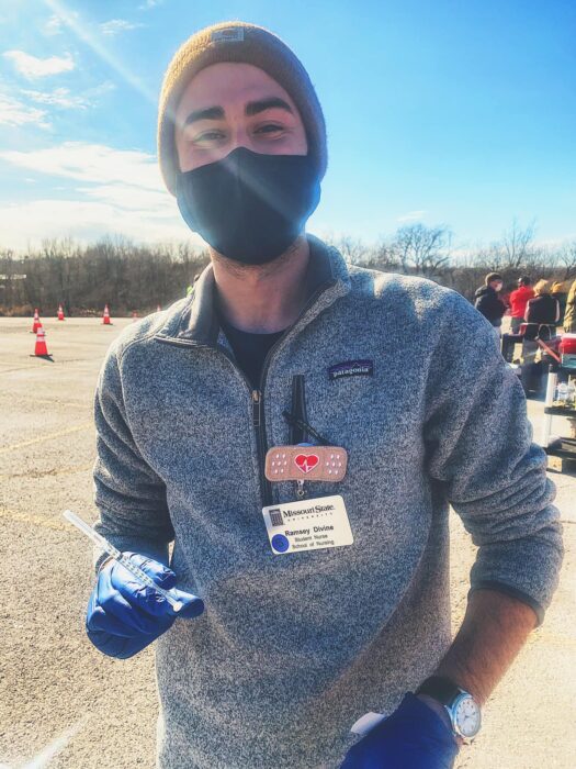 One person outside with a mask and syringe