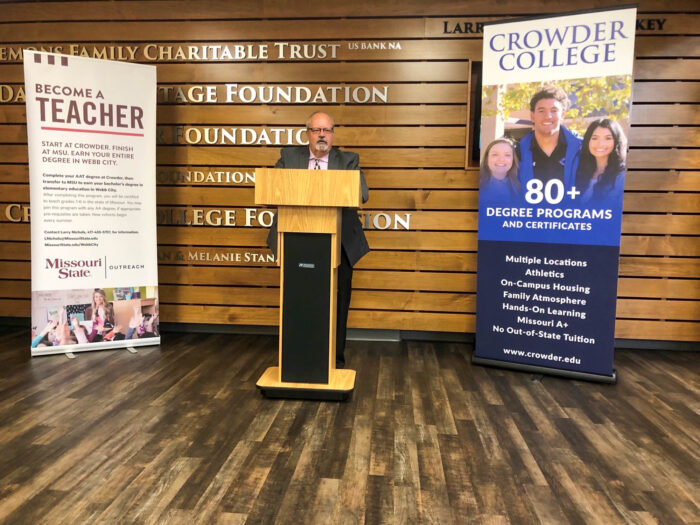 Dr. Coltharp, President of Crowder College, provides remarks behind a podium placed between an MSU and a Crowder College banner 