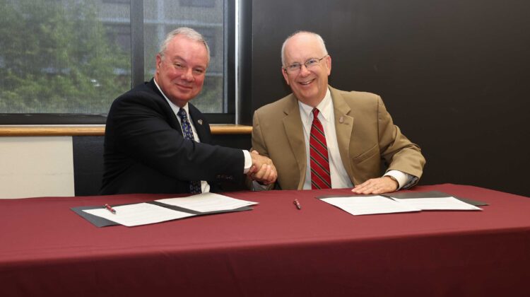 East Central College president Dr. Jon Bauer shakes hands with MSU president Clif Smart.