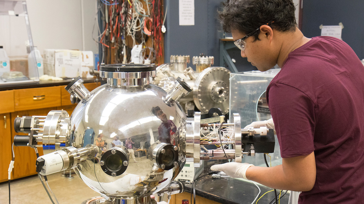 Graduate students and Dr. Kartik Ghosh work with pulsed laser deposition. Pictured, graduate student Mahmud Reaz.