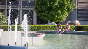 Students sit with feet in fountain